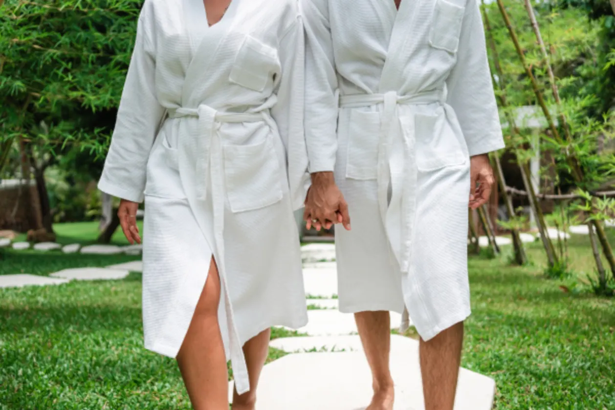 couple wearing bathrobes walking holding hands what to wear at spa resorts